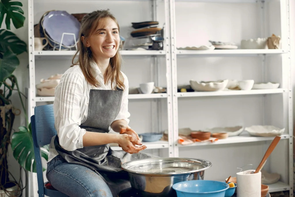 Une jeune femme fait de la poterie dans son salon